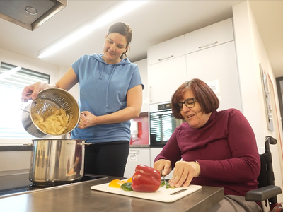 Bewohnerin und Assistentin kochen