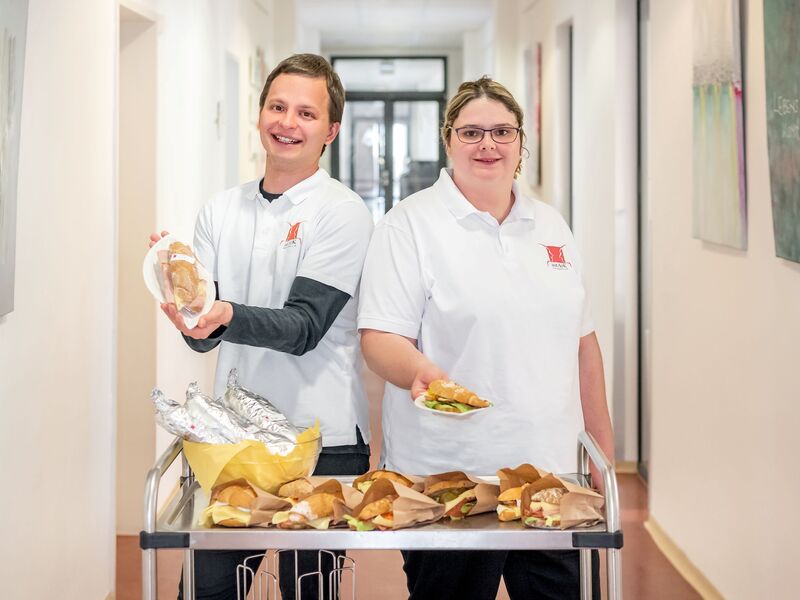 Zwei Mitarbeitende liefern Jause in der Kärntner Landesregierung aus