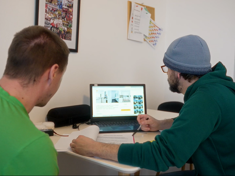 Assistent recherchiert mit Bewohner im Internet