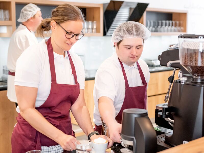 Mitarbeiter*innen bei der Kaffeezubereitung